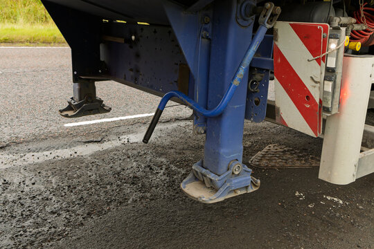HGV blue lorry truck flatbed trailer landing legs raised above road surface