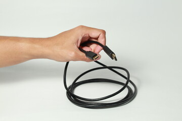 Fototapeta premium Hand holding HDMI cable on isolated white background