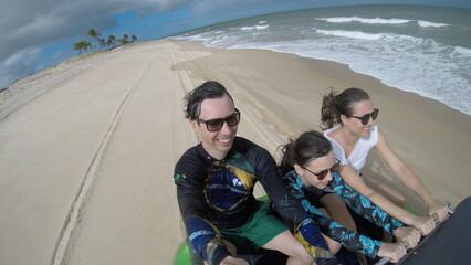 familia feliz em passeio na praia com bugue 