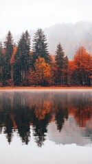Fototapeta premium still lake reflecting vibrant autumn trees in shades of orange red and yellow