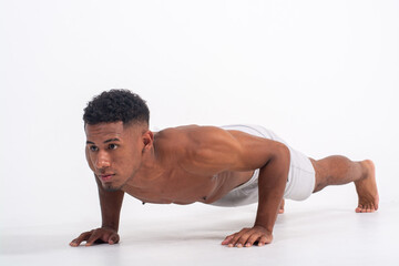 Obraz premium Fit black men concentrated doing a plank shirtless isolated on a white background