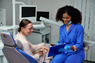 Dentist discusses X-ray with patient, going over details to keep them informed and confident in...