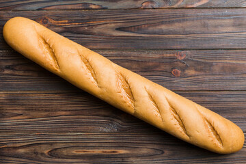 Minimalist french baguette on colored background. fresh bread as background, top view with space for your text or design