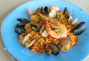 mussels with seafood risotto on a blue plate and prawns 