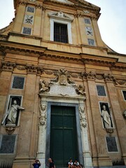 Obraz premium Historic church facade with intricate sculptures in a bustling urban area during sunset