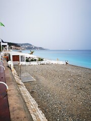 Obraz premium Secluded beach view along the coastline with gentle waves and cloudy sky in the distance showing serene atmosphere