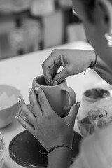 Manos de mujer moldeando taza de ceramica 