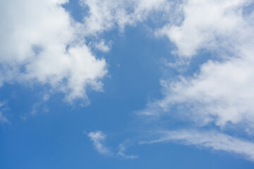 Obraz premium A calm blue sky with fluffy white clouds encapsulated the splendor of a sunny, bright day. The vivid colors and serene cloud formations are ideal for backgrounds and nature-themed designs.