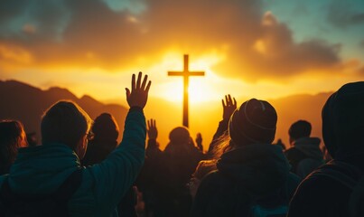 A group of people stand praying at sunset, hands raised in worship, cross in the background