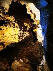 Exploring the hidden depths of a colorful cave in the mountains at sunset with glowing rock...