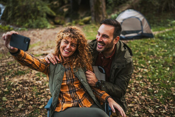 happy couple take a self portrait or have video call in front tent