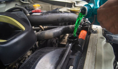 Fototapeta premium Replacing the emerald green coolant of a car radiator To maintain the condition of the engine.