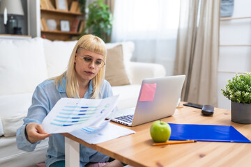 Smiling young woman working at home. Successful professional occupation female work on laptop...