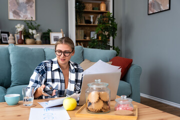 Smiling young woman working at home. Successful professional occupation female work on laptop...