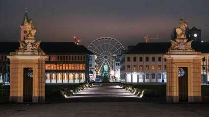 Night panorama of Karlsruhe with the view of the Ferris wheel from the avenue of the city park....
