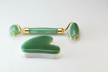 Green jade roller massager for face isolated on white background