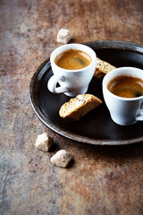 Cantuccini (Italian cookie) and Two Cups Of Coffee on rustic stone background.