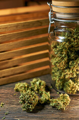 Medical cannabis on a wooden table, green dry buds, cbd oil, healing tincture, cannabinoids