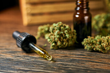Medical cannabis on a wooden table, green dry buds, cbd oil, healing tincture, cannabinoids