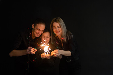 family with sparklers on a black background