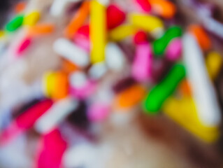 Blurred close-up of colorful sprinkles on a soft surface.