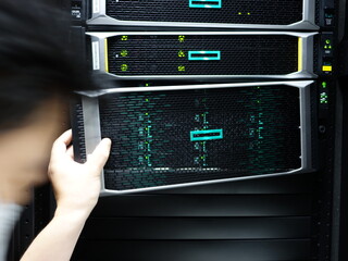 Man fixing server in data center room .