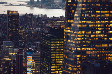 Aerial view of various high Manhattan skyscrapers buildings with lighted windows located in New...
