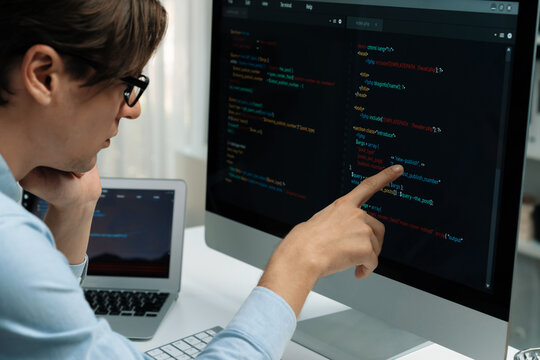 IT developer selecting by point on coding online software development information on pc comparing with laptop screen of new code program's update version firmware overall system project. Pecuniary.