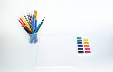 Top view of watercolors in a container and brush. Palette and shades of paint colors. Background with brush and paint for drawing.