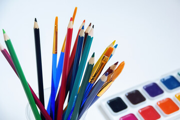 Top view of watercolors in a container and brush. Palette and shades of paint colors. Background with brush and paint for drawing.