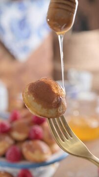 Dutch Mini Pancakes .Poffertjes Drizzled with Syrup Sweet Breakfast Treat. known as poffertjes, drizzled with syrup and served as a delightful breakfast or dessert. Perfect for food blogs,social media