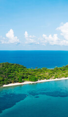 Obraz premium Aerial scenery view of picturesque island with crystal azure water and green vegetation.Bird's eye view of paradise beach shoreline, beautiful touristic destination for summer vacations,