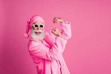 Naklejka premium Profile portrait of eccentric aged man flex biceps empty space wear hat fleece bathrobe isolated on pink color background