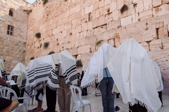 Cohanim or Jewish priests cover their heads with their prayer shawls and recite a blessing for God's protection during morning prayers at the Western Wall in Jerusalem, Israel.