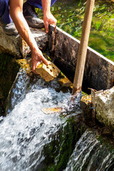 Obraz premium Two hands of a worker repairing and strengthening a dam at Kleptuza Lake in the town of Velingrad, Pazardzhik Province, Southern Bulgaria