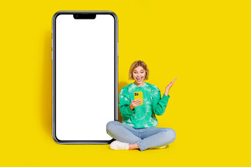Full length photo of shiny impressed lady dressed tie dye sweatshirt making orders modern gadget empty space isolated yellow color background