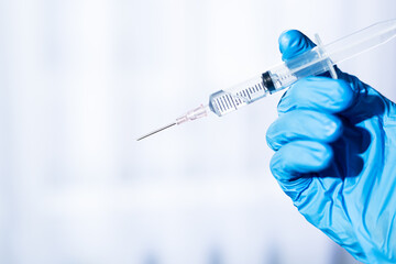 Close-up of syringe needle,Doctor in white coat drawing vaccine into a syringe for injection.