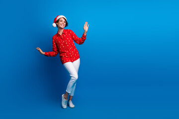 Fototapeta premium Full size photo of pretty young woman dancing empty space christmas festive time isolated on blue color background
