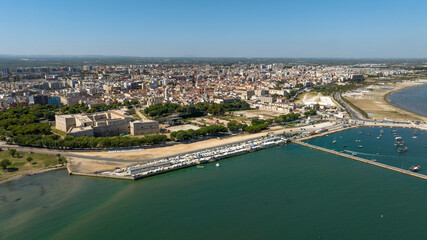 Fototapeta premium Aerial view of the castle located in Barletta, Puglia, Italy. It was a medieval fortress built for defense and today it is a museum. There is a park around the fort. In foreground is the Adriatic sea.