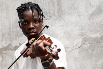 Candid of African man model with dreadlocks hairstyle wearing white t-shirt playing violin standing at the background