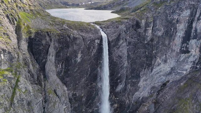The drone zooms in and rises slowly behind mountains and Mardalsfossen in Eikesdal comes into view. The waterfall is one of the tallest waterfalls in Europe. A whopping 705 meters of waterfalls. 4K.