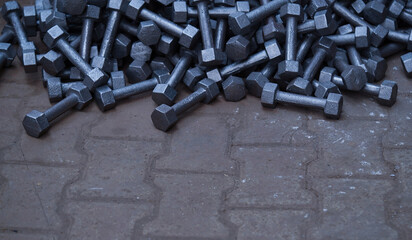 heap of raw and unfinished cast iron dumbbells 