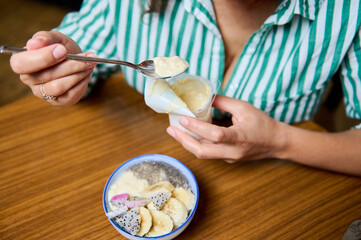 Woman enjoying a healthy breakfast with fruit and yogurt