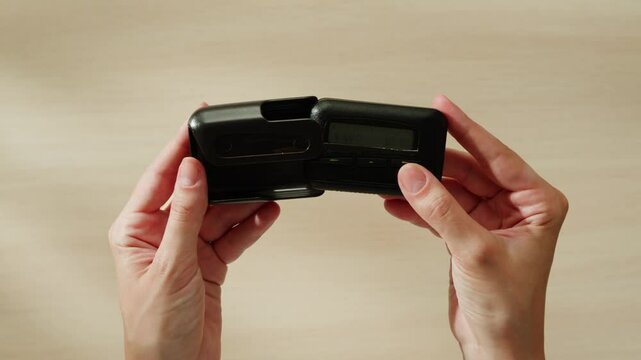 Pager beeper device close up on a desk, retro phone 90s instant communication and connection, sms messaging in the early 80s 90s digital age