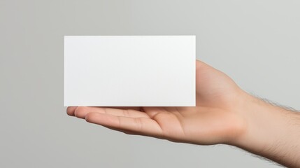 Fototapeta premium Minimalist Hand Holding Blank Business Card on Neutral Background