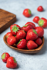 Closeup view of strawberries in wooden bowl. Fresh organic berry fruit bowl