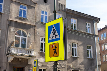 Pedestrian sign in Poland. Warning road sign with a picture of children. Blue and white crosswalk sign. Traffic sign - a pedestrian crossing against the blue sky.
