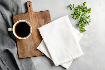 Two folded kitchen towels on a cutting board. Cup of cofee and green potted plant. Soft natural lighting, high-resolution texture,  focus on fabric details, professional and realistic appearance