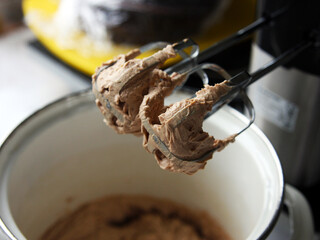 Chocolate cream and sauce on the top of the mixer on the background of a white saucepan. Dessert in the kitchen at the pastry shop. Homemade cakes and food