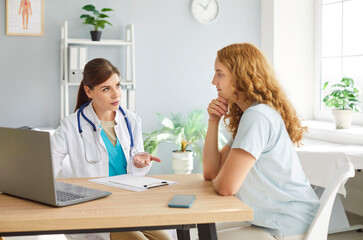 Female therapist near digital laptop showing health test check up result to share treatment plan to...